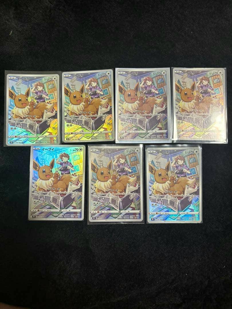 Seven Eevee CHR Pokémon trading cards in sleeves arranged on a dark background showing the card fronts.