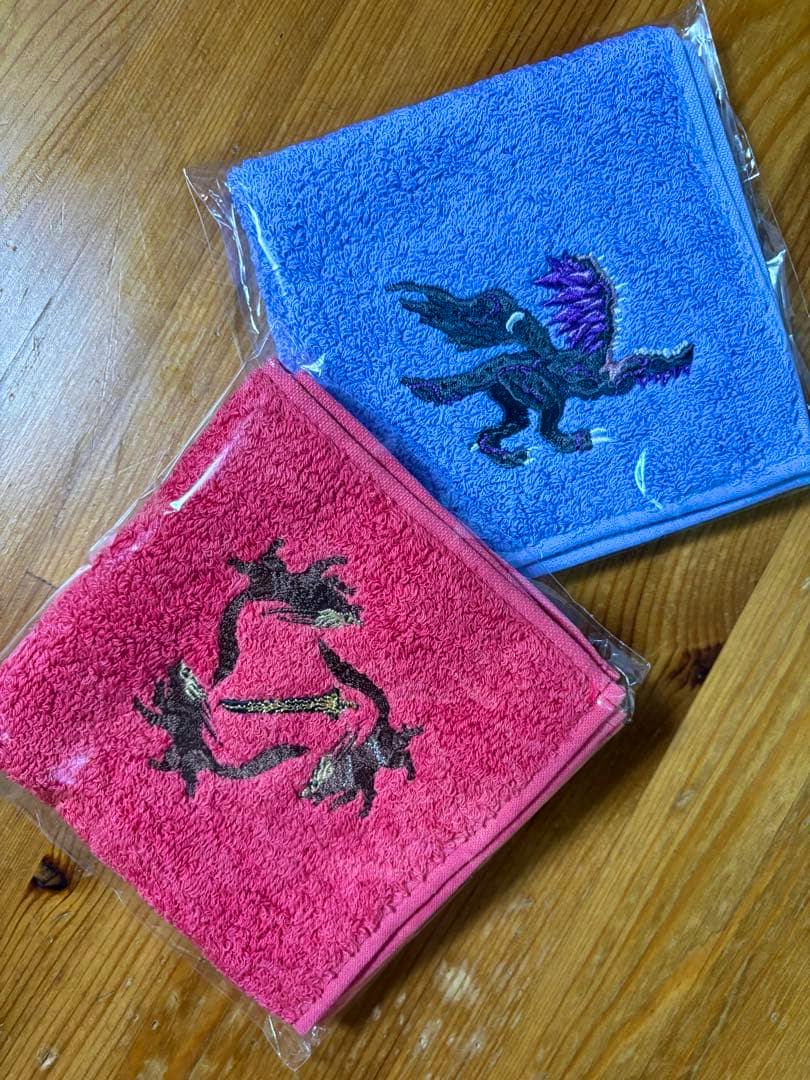 Two Elden Ring Night Rain handkerchiefs—one blue and one pink—with embroidered motifs, placed on a wooden surface.