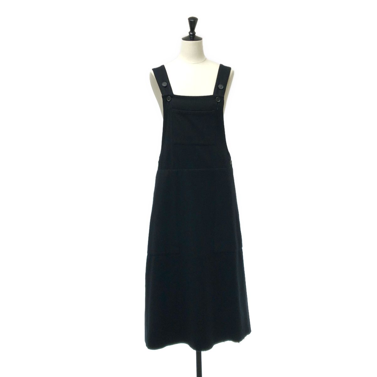 Black jumper skirt dress displayed on a mannequin against a white background.