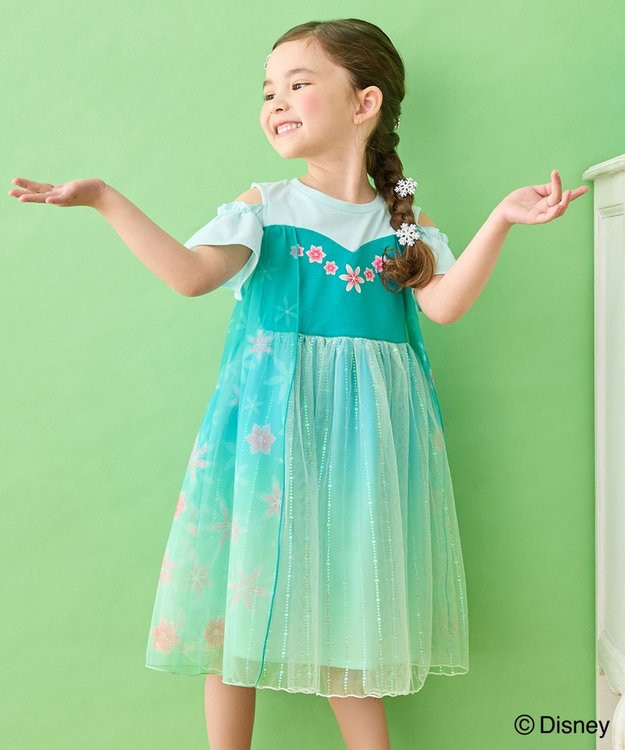 A child model wearing a teal Elsa dress with a floral bodice and sparkly tulle skirt against a green background.