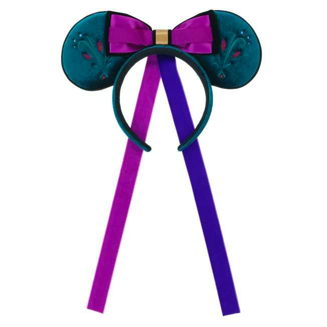 A teal ear-shaped headband with a purple bow and two long purple ribbons hanging down.
