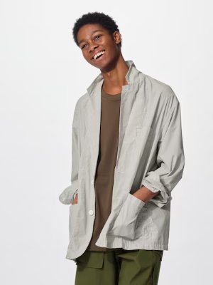Model wearing a light-colored men's jacket with front buttons and side pockets.