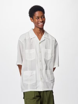 A model wears a white Cuban shirt (5分袖) with short sleeves, vertical pleats, and front patch pockets.