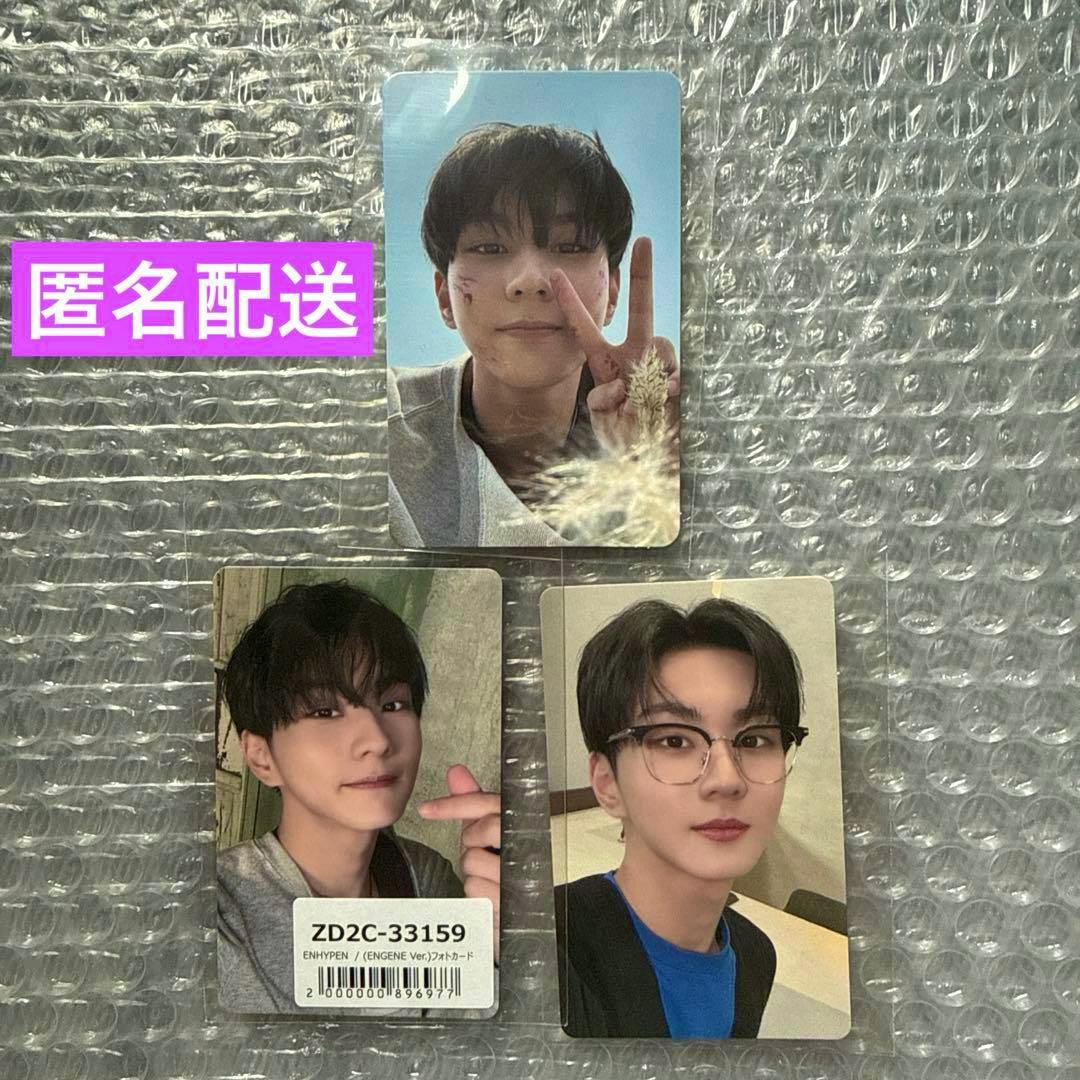 Three photocards arranged on bubble wrap—two at the bottom and one at the top—with a barcode sticker and a purple text label visible.