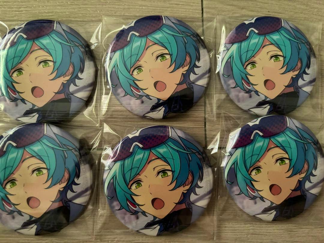 Six sealed round can badges (あんスタ 深海奏汰 缶バッジ) showing the character's face arranged in two rows on a wooden surface.