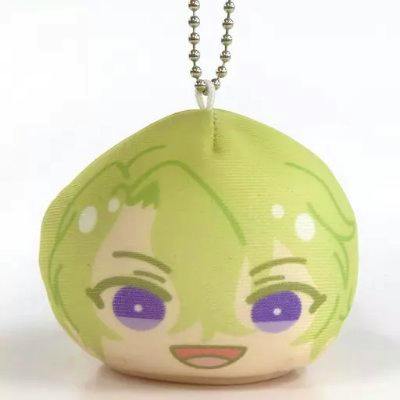 Front view of a round plush keychain mascot showing a green-haired character face with purple eyes and an attached metal ball chain.
