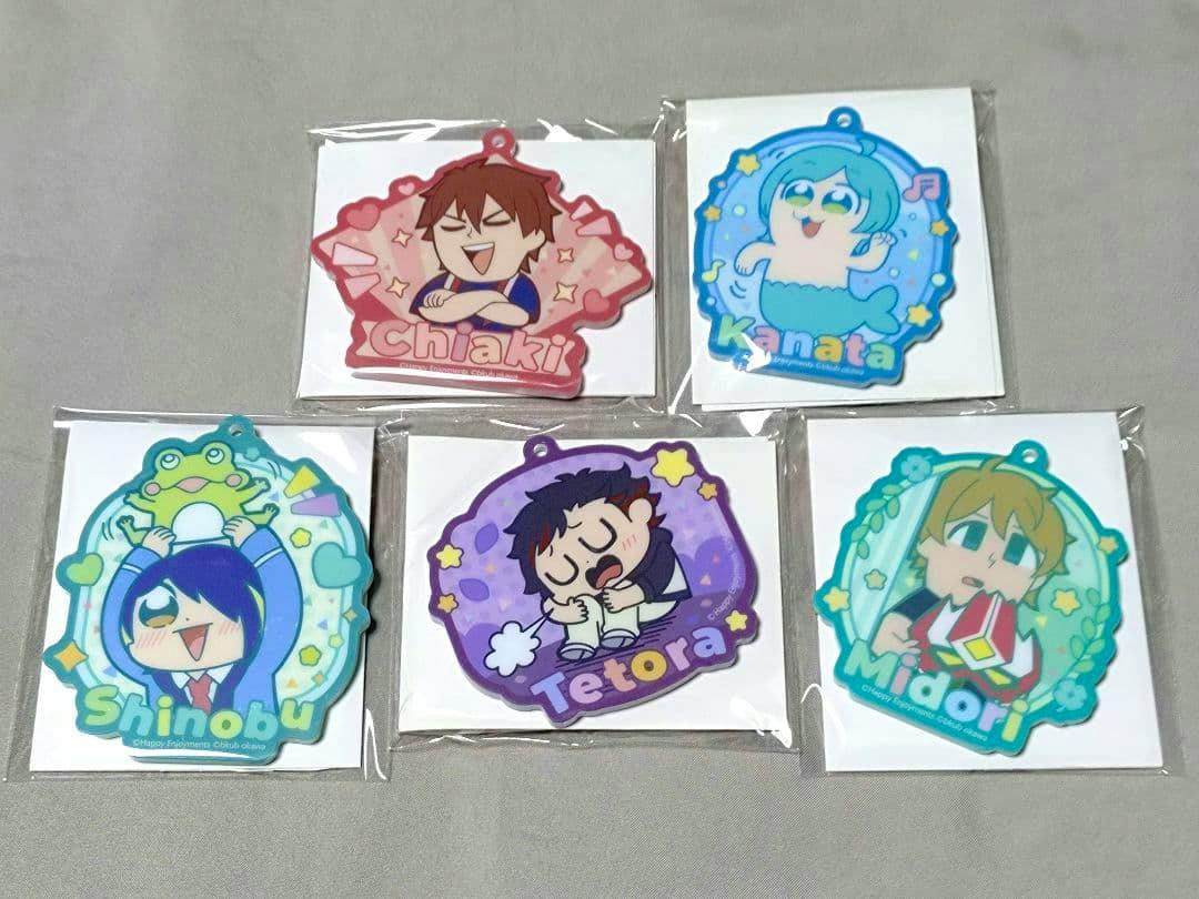 Photo of six packaged acrylic keychain charms featuring chibi Ryuseitai character designs arranged on a gray surface.
