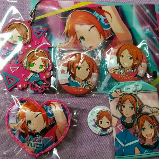 Photo of multiple Ensemble Stars! character goods for Aoi Yuta and Aoi Hinata: several round badges, a rubber strap charm, an embroidered heart patch, and a small fabric charm arranged on a purple surface.