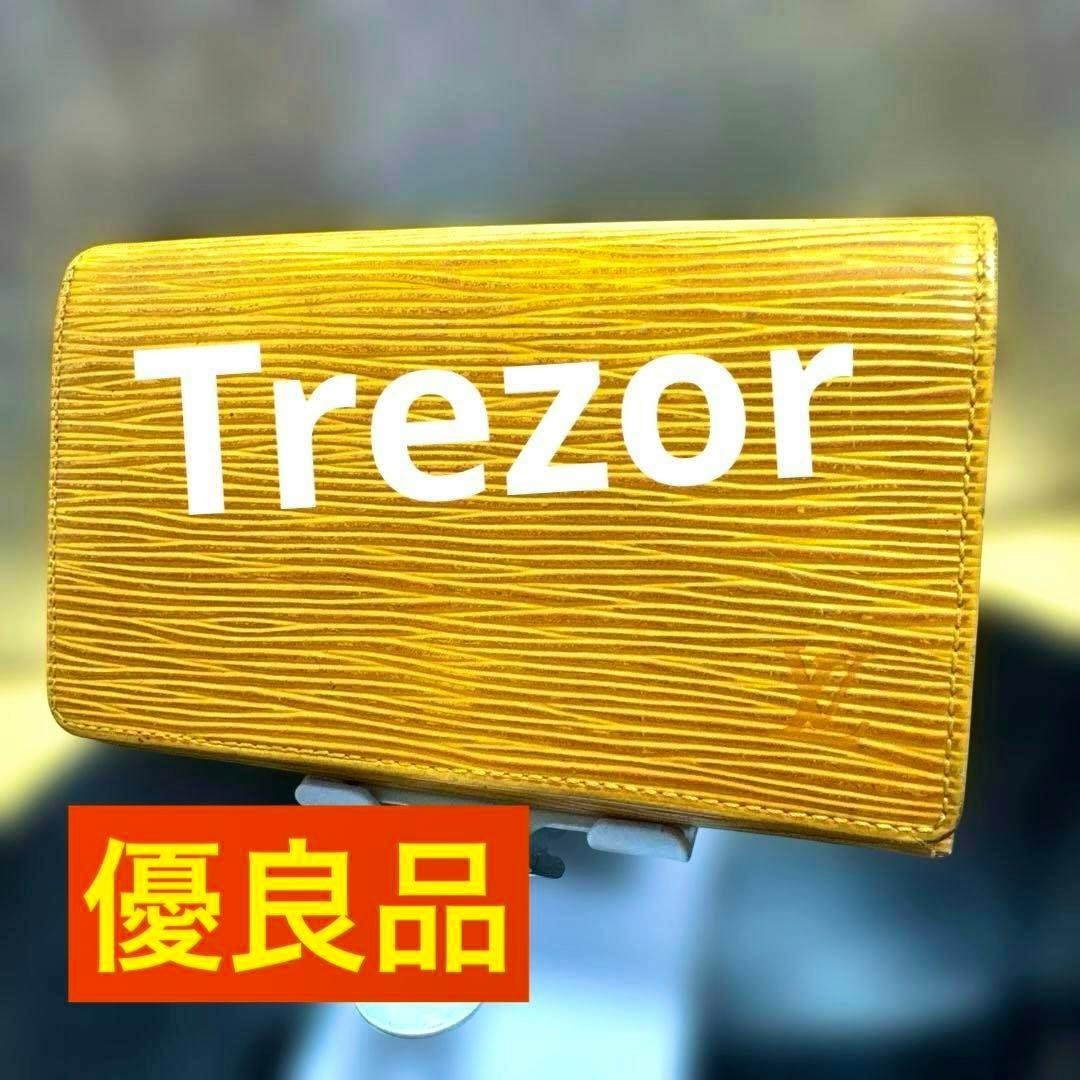 Yellow Epi-pattern folding wallet shown closed with textured surface, a large 'Trezor' watermark, and an orange label reading '優良品'.