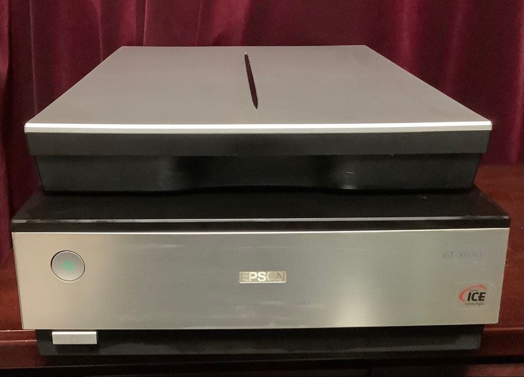 Front view of the EPSON GT-X970 film scanner with the lid closed, showing the control button and logo.