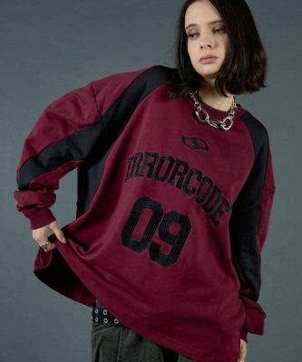 Model wearing an oversized burgundy and black crewneck sweatshirt with large "09" number and lettering on the front.