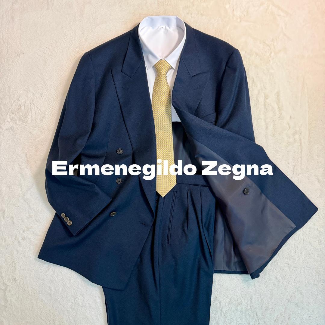 Navy double-breasted men's suit jacket and trousers laid flat with a white shirt and yellow tie.