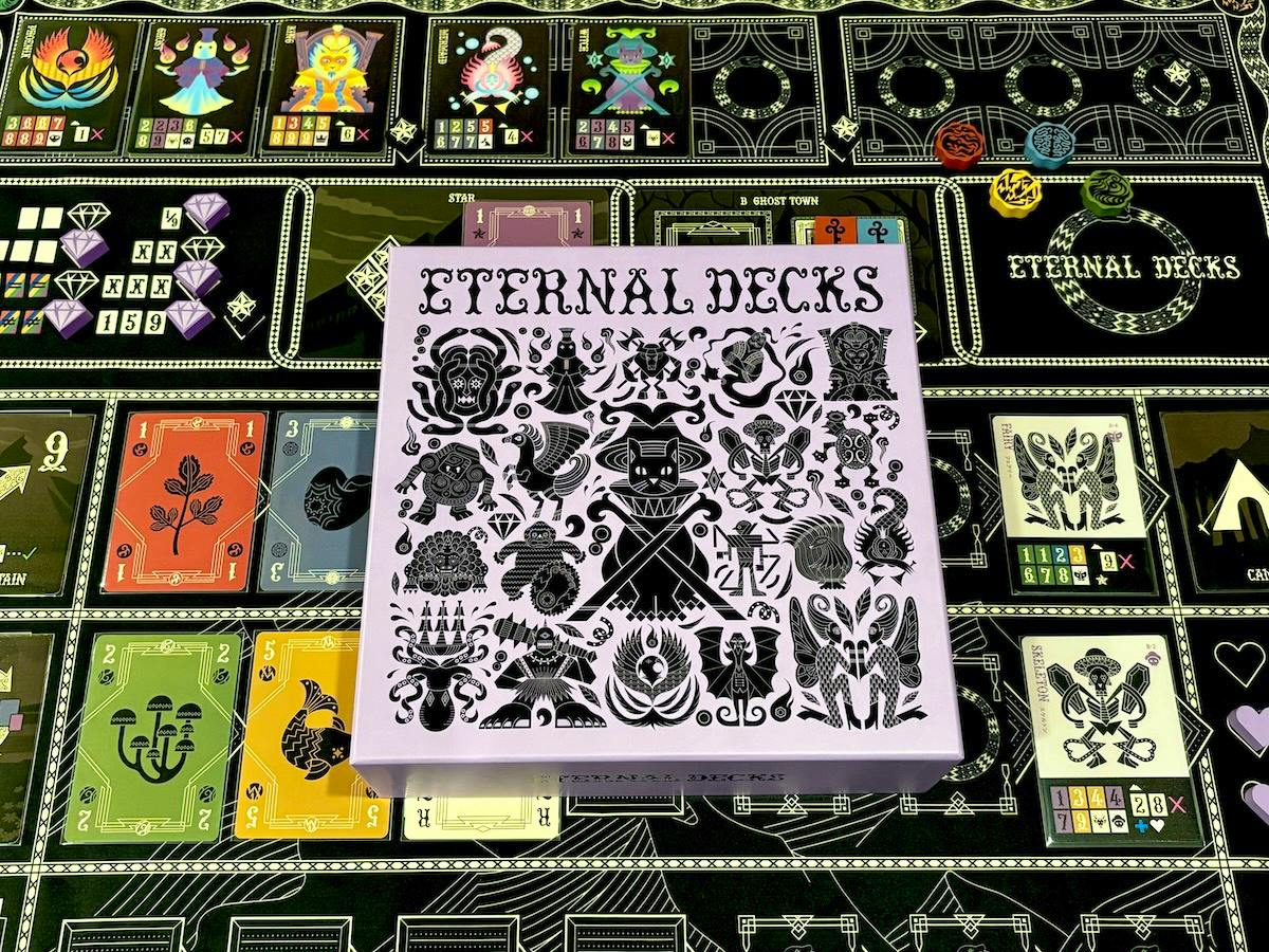 A purple "Eternal Decks" card game box with black decorative illustrations shown on a game mat.