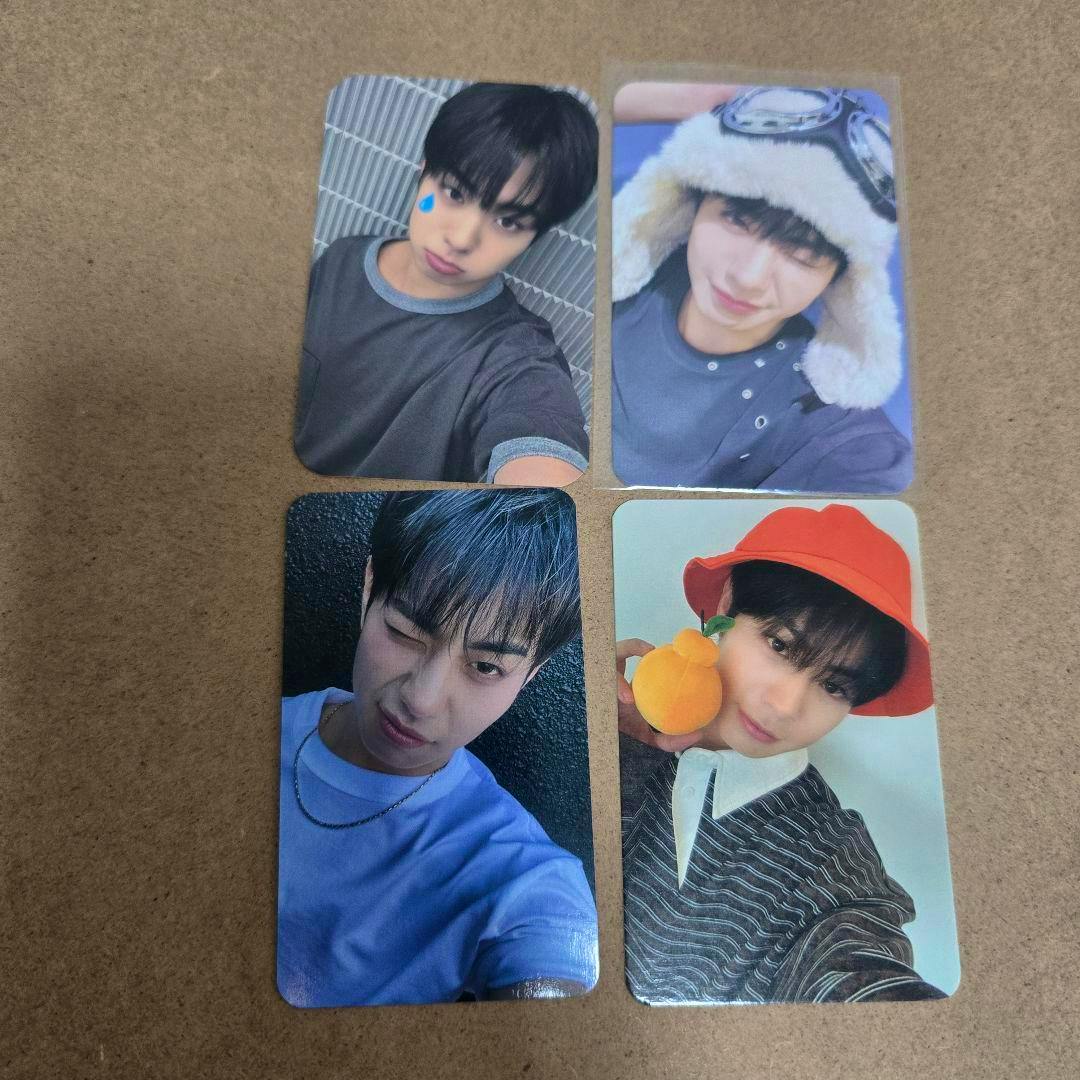 Four EVNNE トレカ ケイタ photocards arranged in a 2x2 grid on a brown surface.