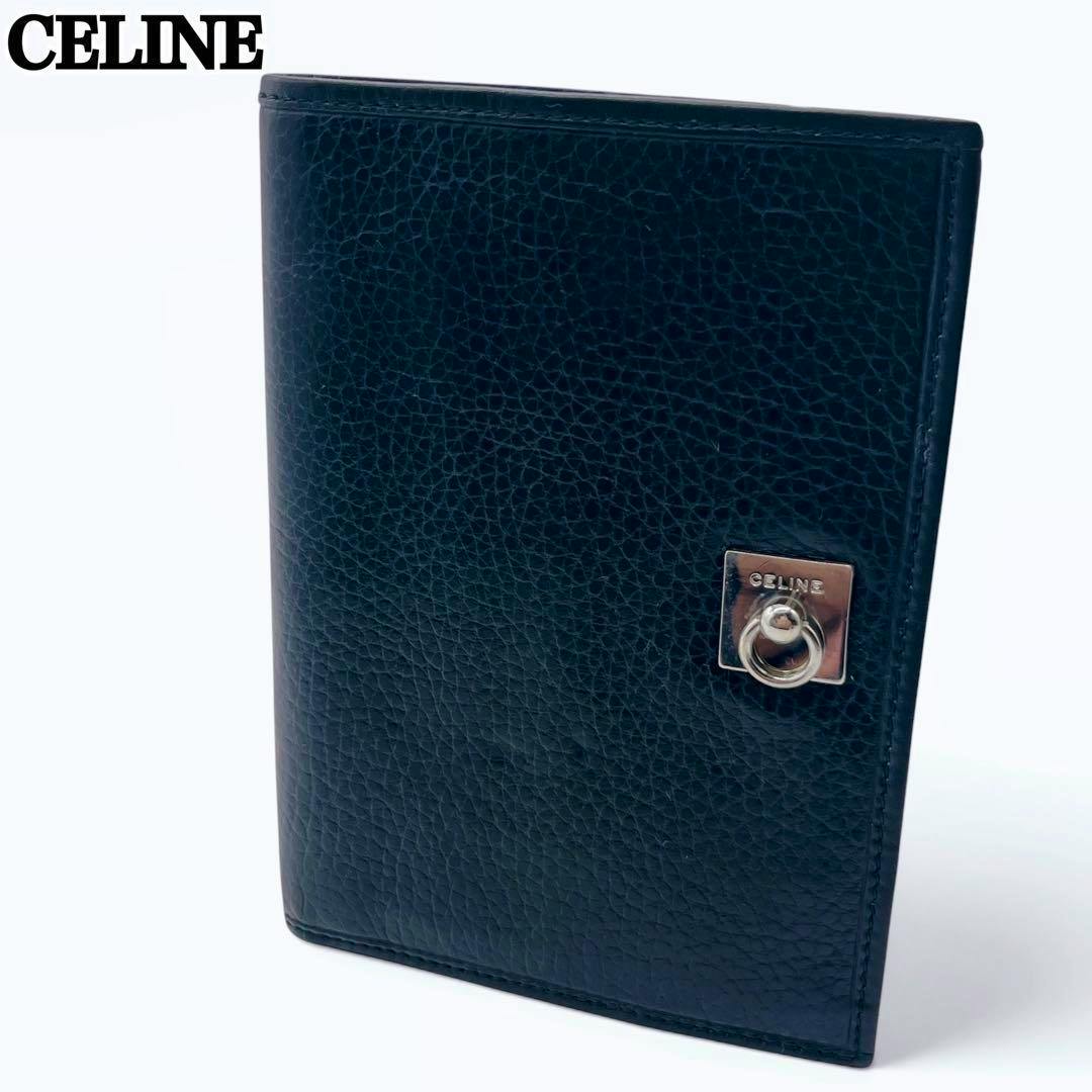 Closed Celine bi-fold card case in pebbled (shibu) leather showing the square metal Gancini ring hardware on the front.