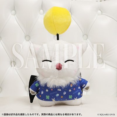 Front view of the Mowgli plush toy: white plush wearing a blue patterned shirt with a yellow pom on a black stalk.