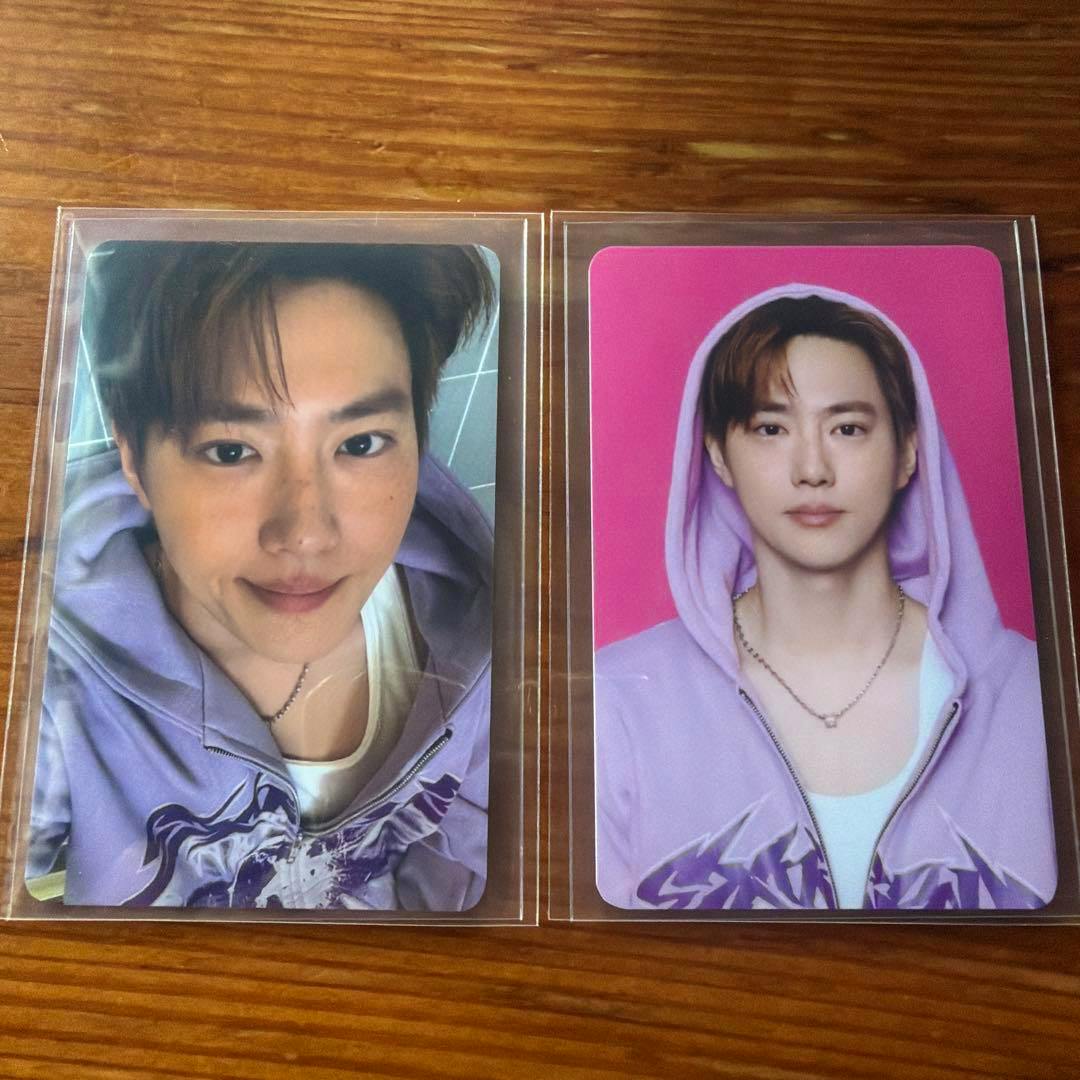 Two photocard fronts in plastic sleeves showing portrait-style images on a wooden surface.