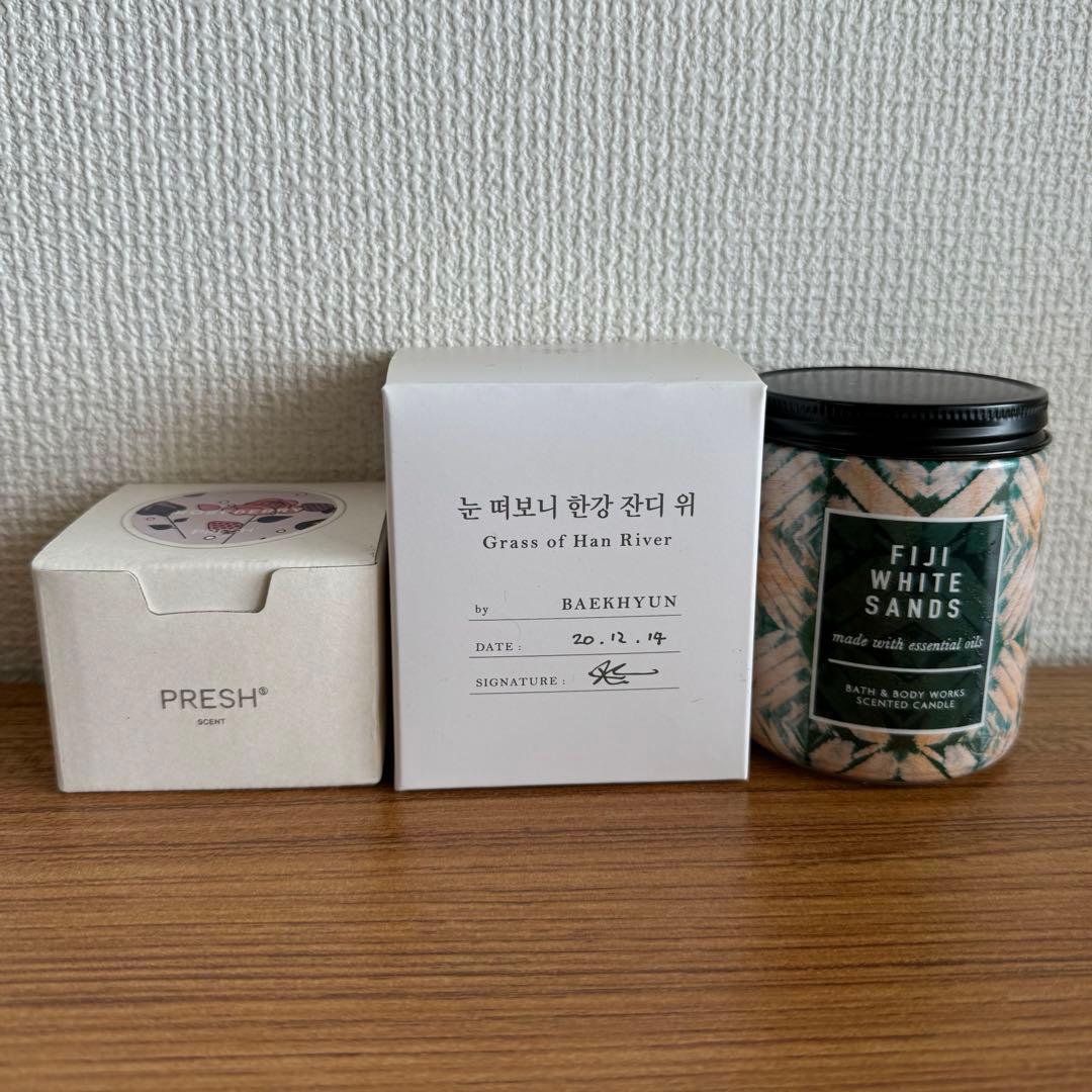 Three candle packages (two boxes and one jar) for the EXO ベッキョン candle set displayed on a wooden surface.