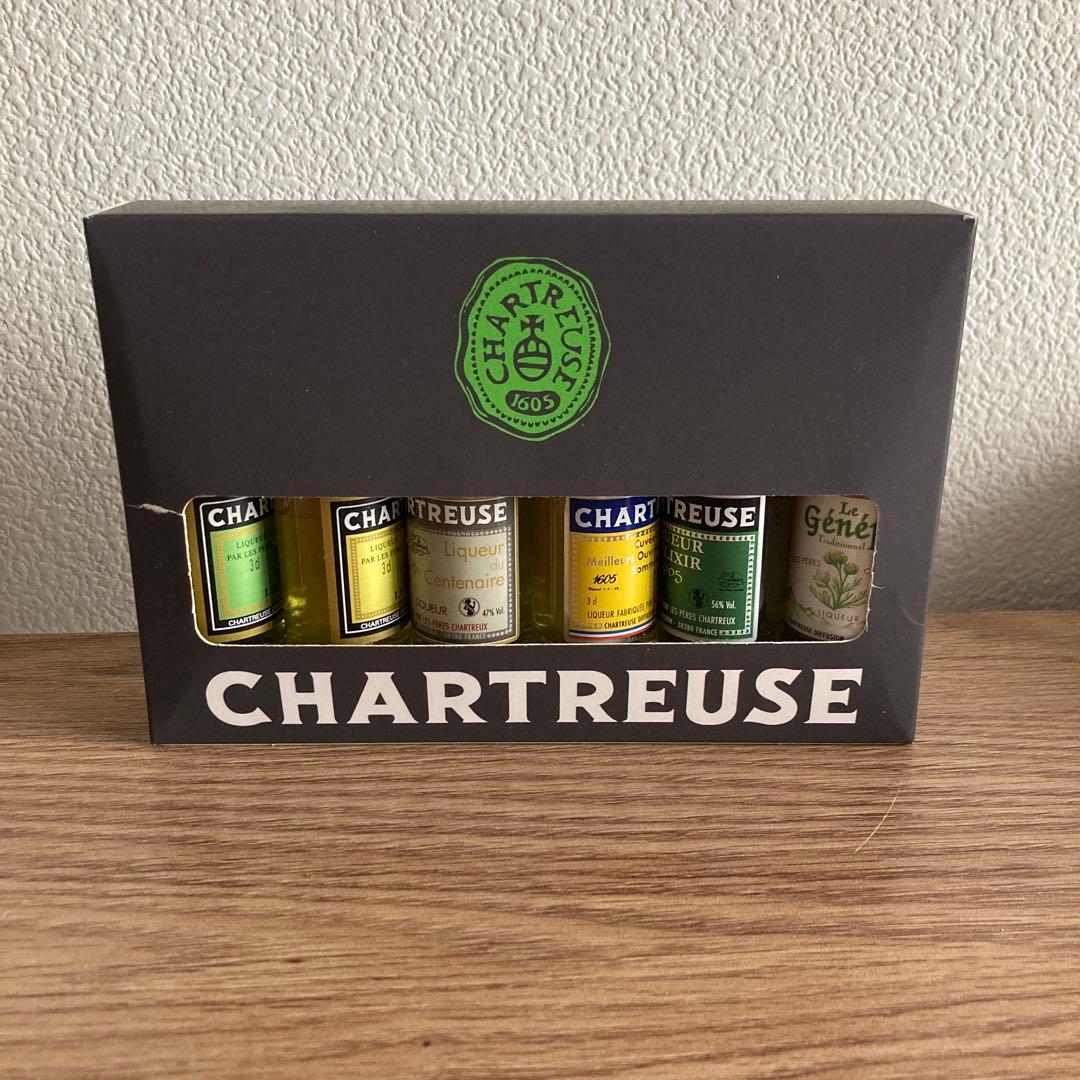 Front view of a boxed set containing six Chartreuse mini bottles visible through a window.
