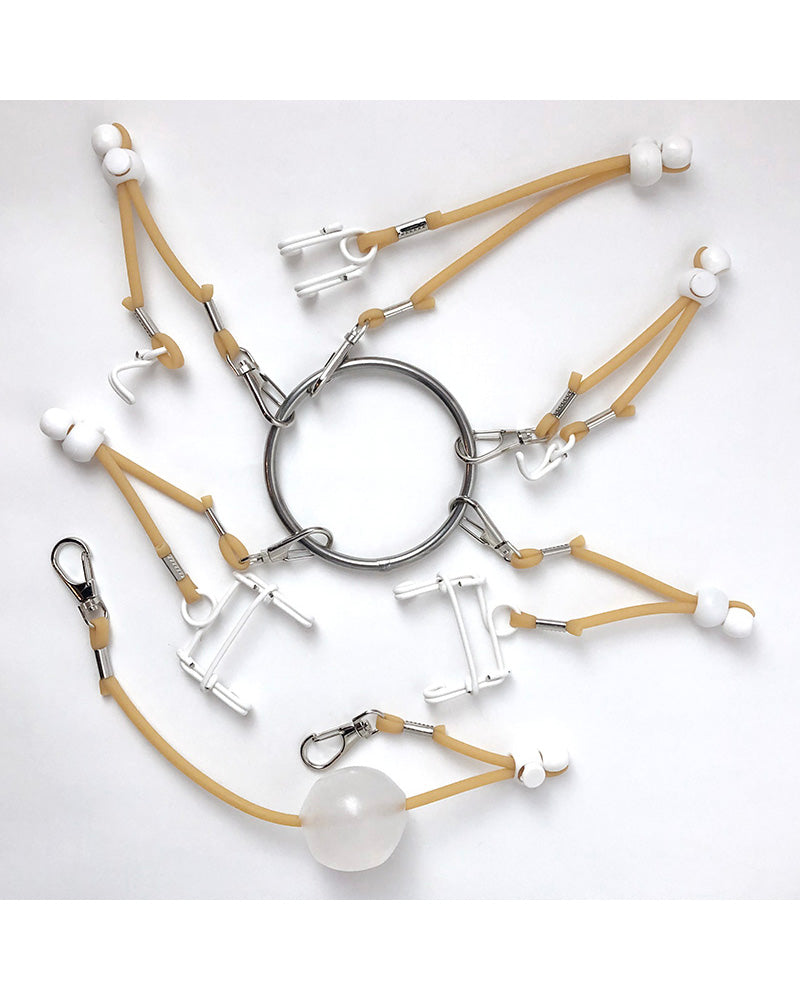Overhead photo of multiple white plastic hooks and beige elastic straps attached to a metal ring on a white background.