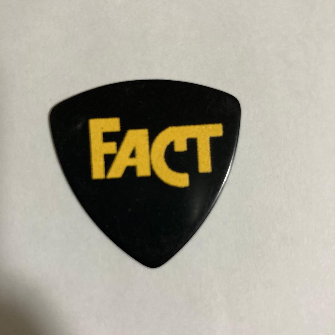 Black plastic guitar pick showing a yellow "FACT" logo.