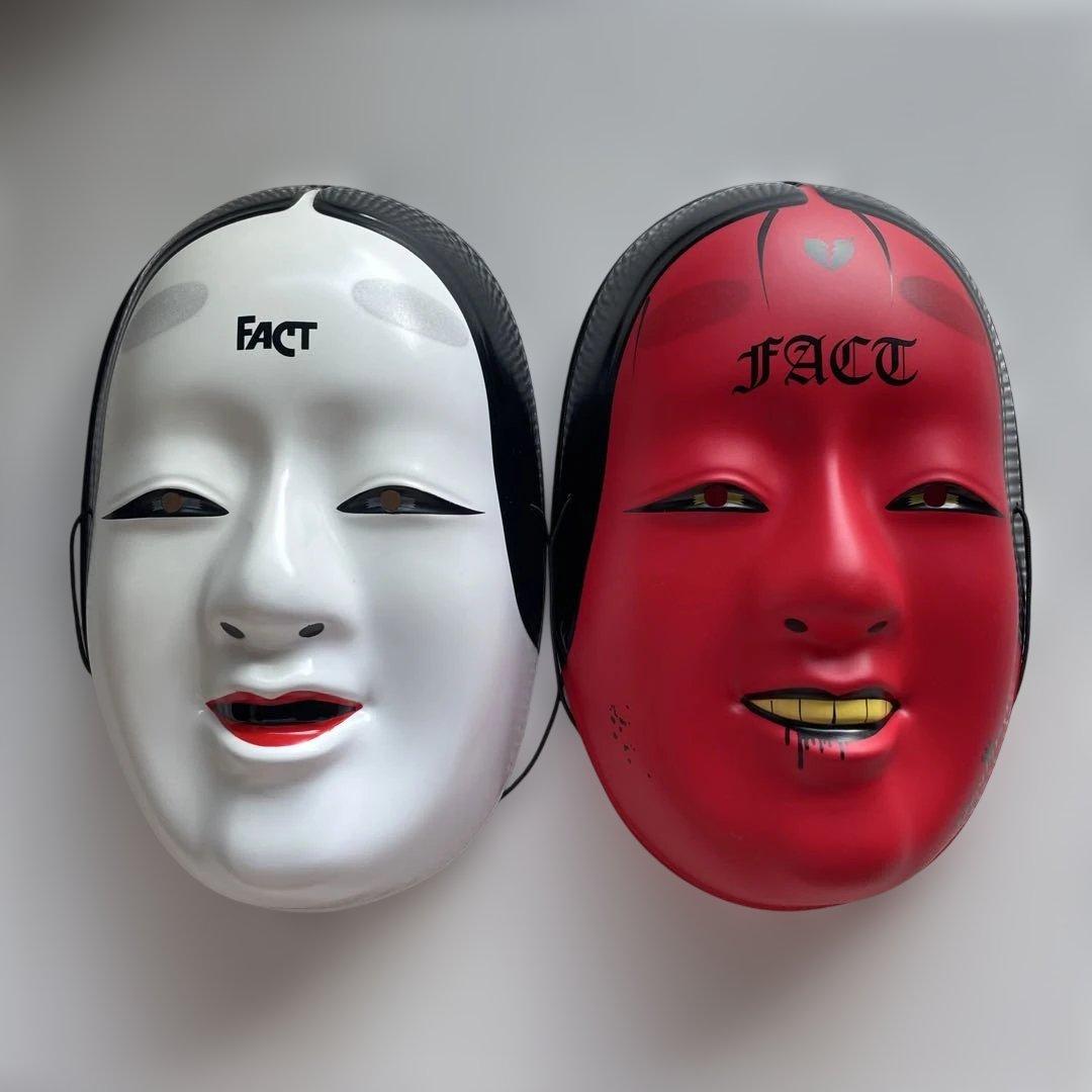 Two Japanese Noh-style masks (one white and one red) displayed side by side with "FACT" printed on their foreheads.