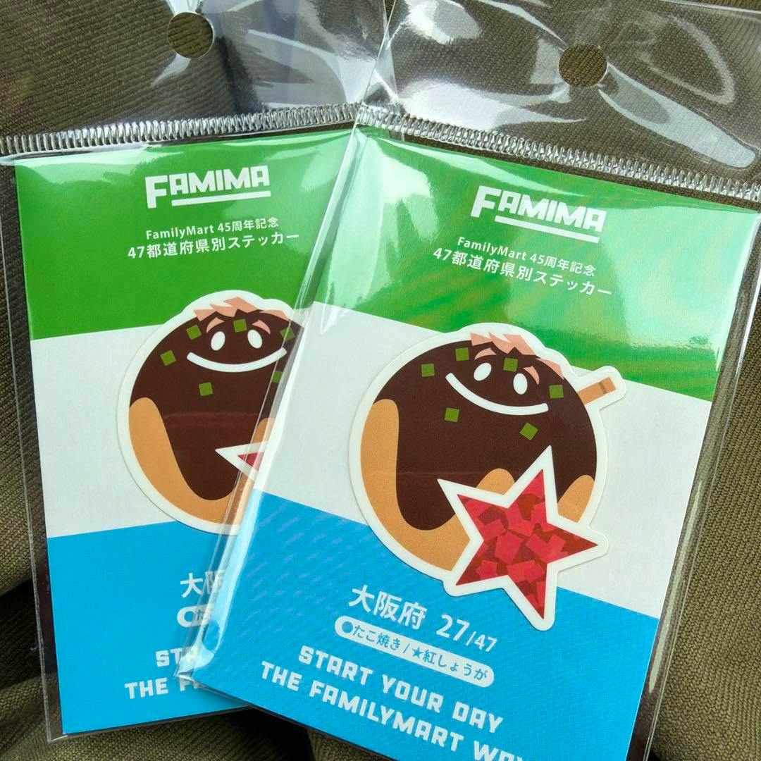 Two packaged FamilyMart Osaka-prefecture stickers (2-piece set) showing a smiling takoyaki character on green and blue backing cards.