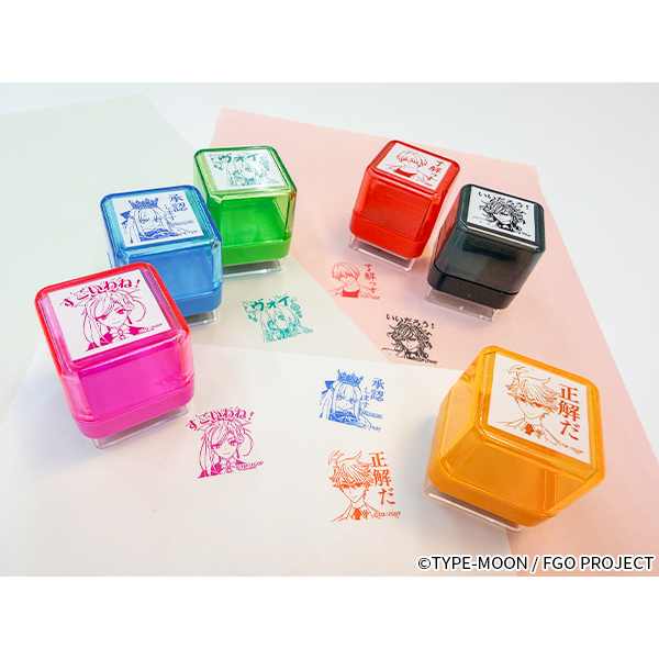 Photo of six colored plastic Fate/Grand Order character stamp blocks and their stamped impressions on paper.