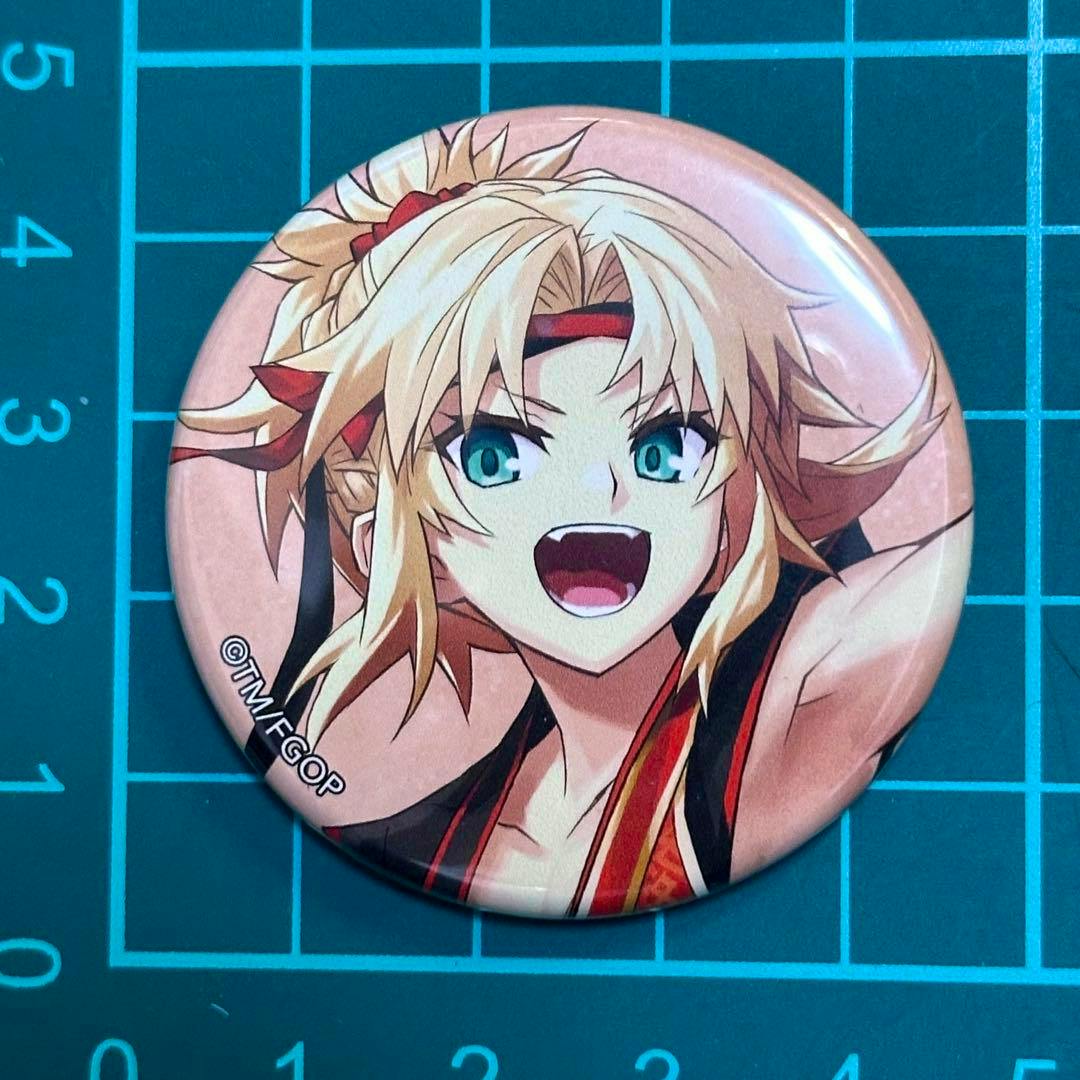 Front of a round FGO can badge showing the モードレッド character artwork on a cutting-mat background.