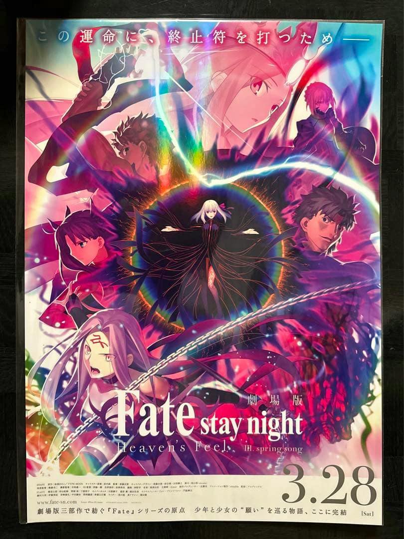 Photograph of the theatrical Fate/stay night: Heaven's Feel movie poster showing multiple characters arranged around a central dark circle and the film title at the bottom.