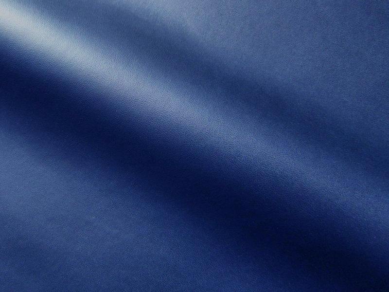 Matte navy synthetic leather (polyester) fabric shown draped with a visible fold and fine texture.
