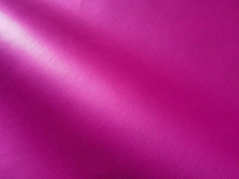 Close-up of thin rose-pink matte synthetic leather (polyester) fabric showing the surface texture.