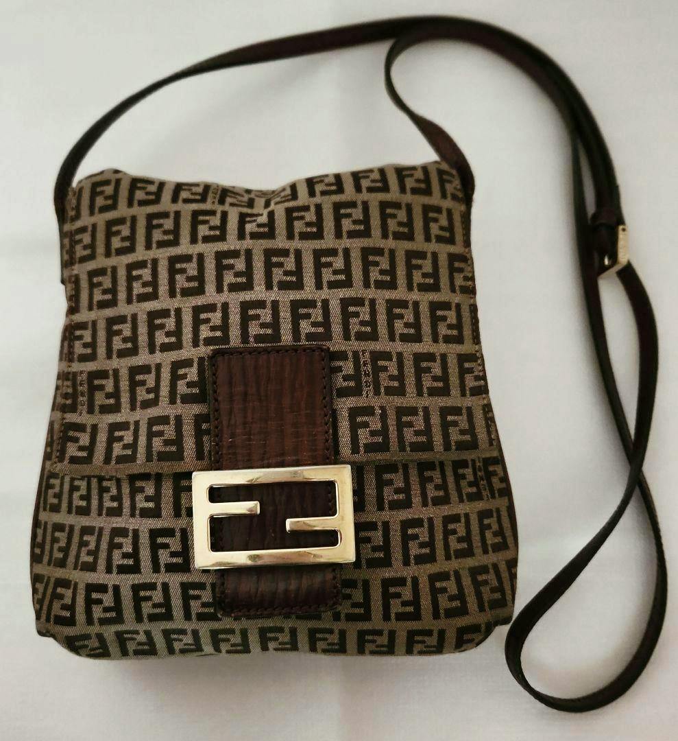Front view of a FENDI shoulder bag in brown FF monogram canvas with a leather strap and rectangular FF metal buckle.