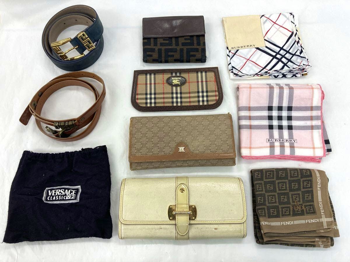 Flat lay photo of a 10-piece set of wallets, belts, and branded scarves on a white background.