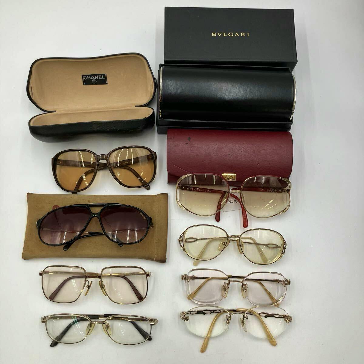 Overhead view of a set of eyeglasses and sunglasses with several eyeglass cases on a white background.