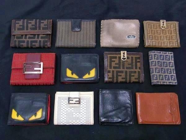 Twelve FENDI wallets and small leather wallets in various colors and patterns arranged on a black background.