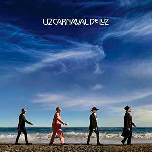 CD cover artwork showing four figures walking along a sandy beach shoreline under a blue sky.