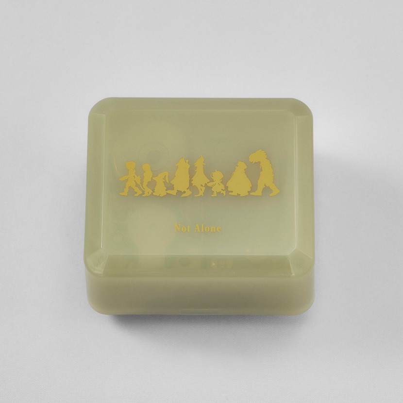Top view of a square translucent music box lid decorated with gold Final Fantasy IX character silhouettes and the text "Not Alone".