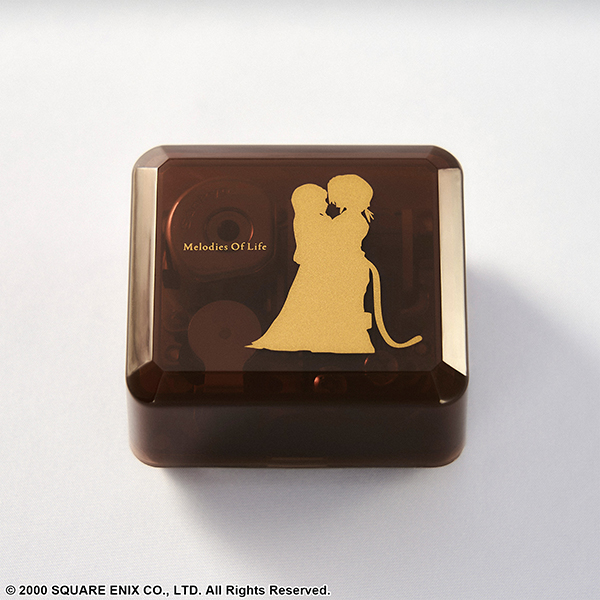 Square brown translucent music box with a gold silhouette of two people and the text "Melodies Of Life" on the lid.