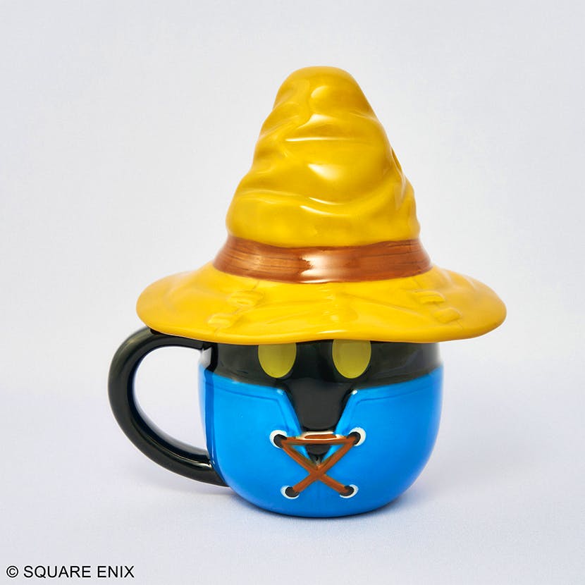 Ceramic Final Fantasy IX Vivi face mug showing a yellow hat, yellow eye shapes, blue coat details, and a black handle.