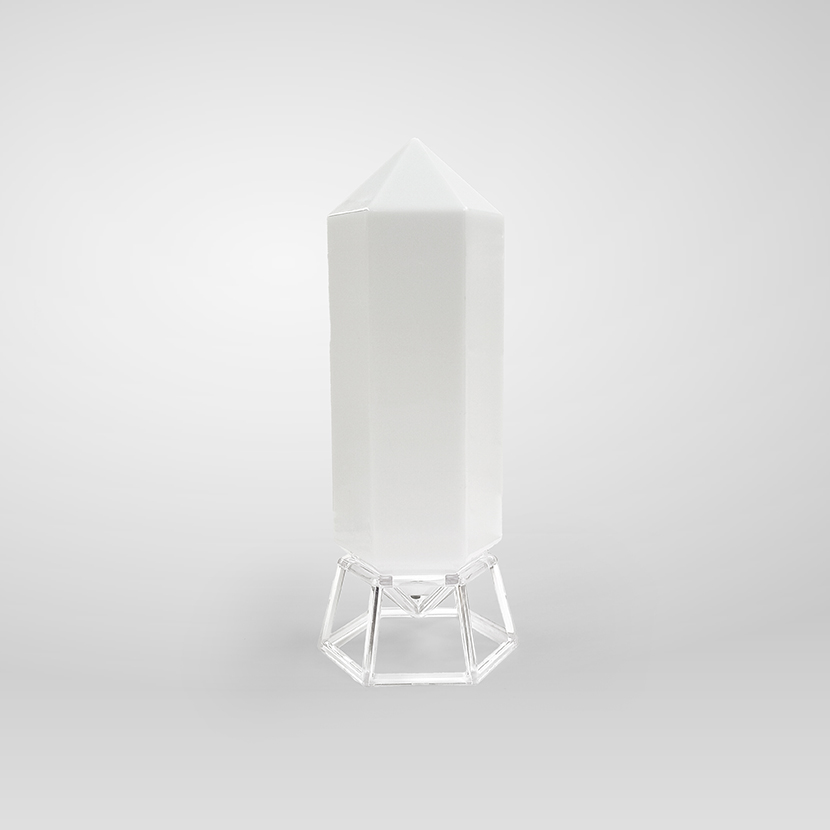 Crystal-shaped LED table lamp standing on a clear geometric stand against a plain white background.