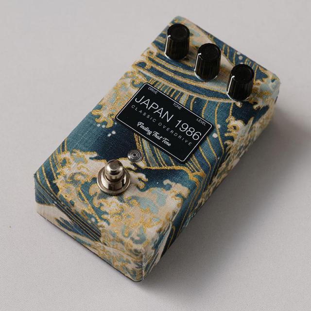 A used Finding That Tone JAPAN 1986 NAMI guitar effector pedal with a wave-patterned enclosure, three control knobs, a footswitch, and a label reading "JAPAN 1986."