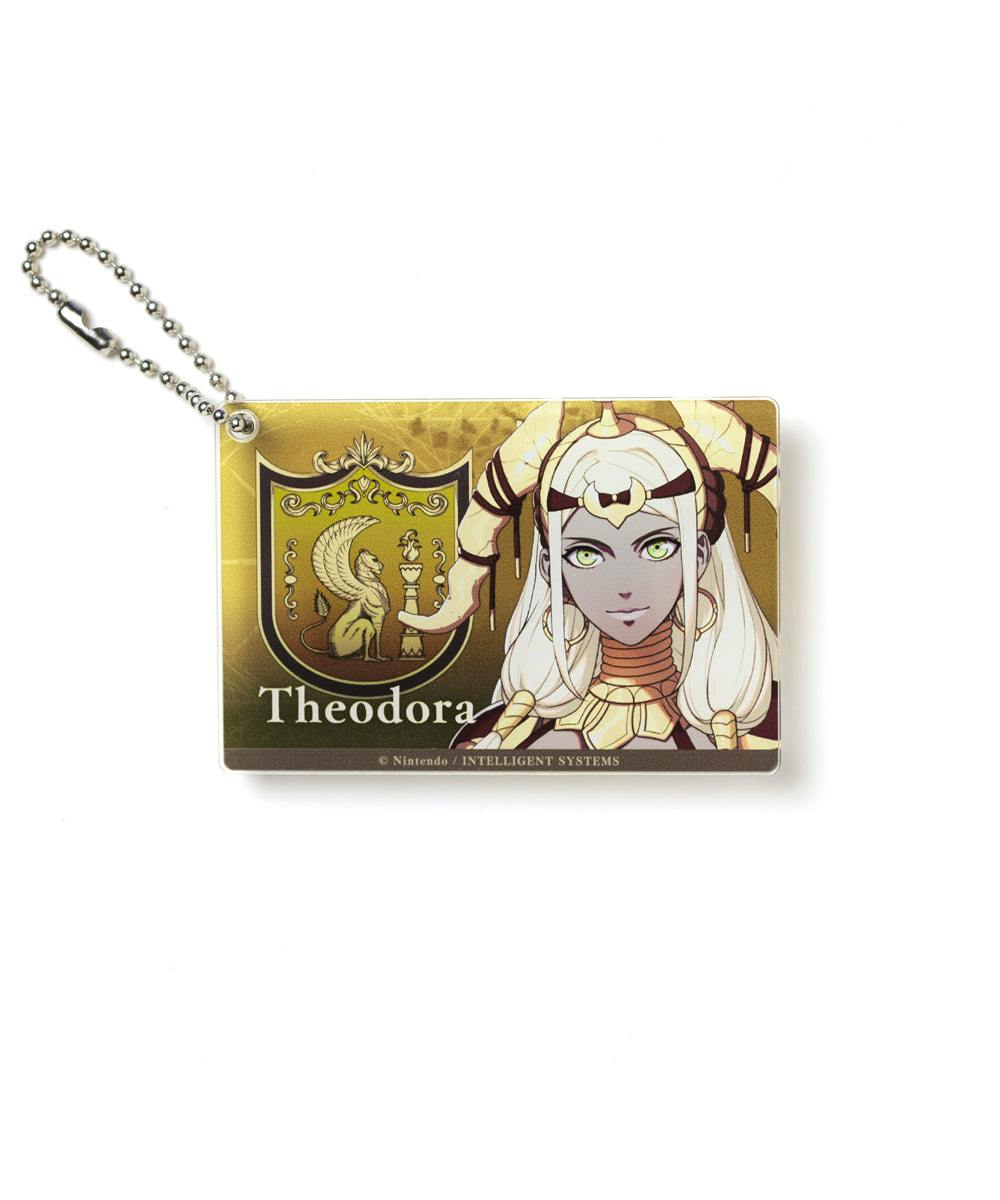 Rectangular acrylic keychain showing Theodora character artwork and a crest on a white background.