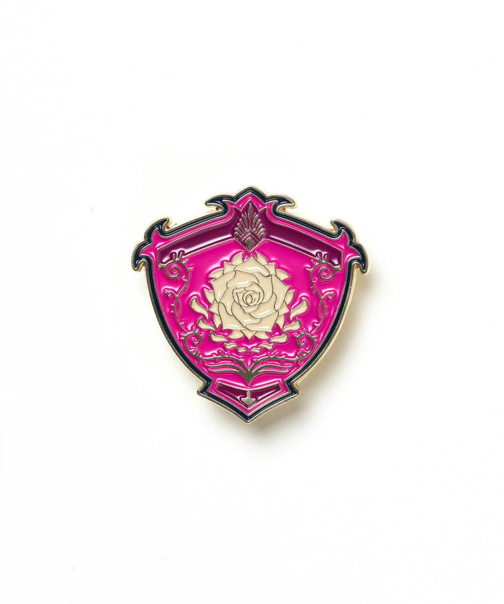 Shield-shaped pink enamel pin featuring a cream-colored rose motif on a white background.