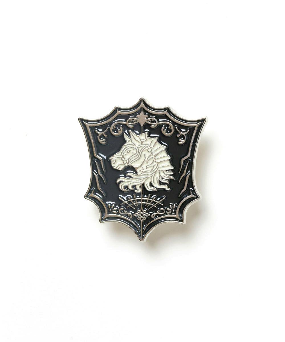 A shield-shaped enamel pin depicting a silver horse-head crest on a black background.