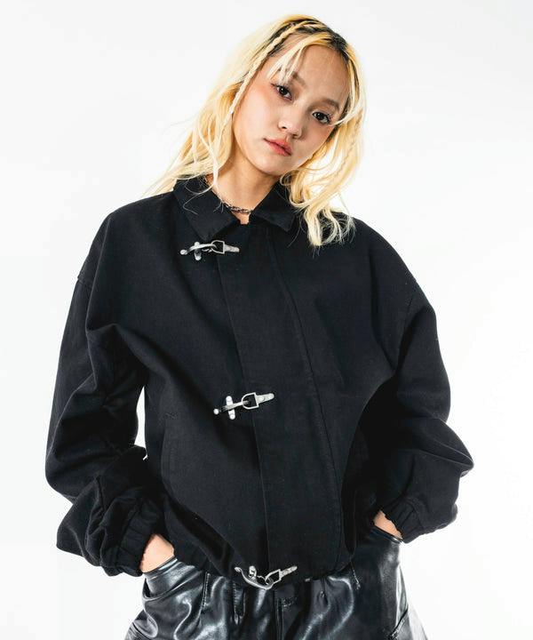 Model wearing a black men's cotton woven fireman jacket with three visible metal clasp closures.