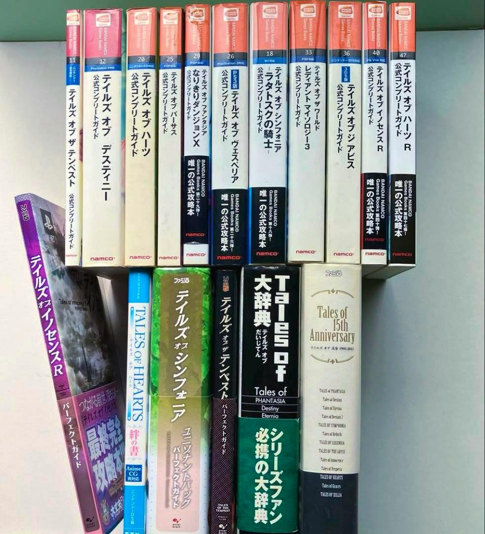 Seventeen "Tales of" series Japanese guidebooks arranged upright showing their spines.