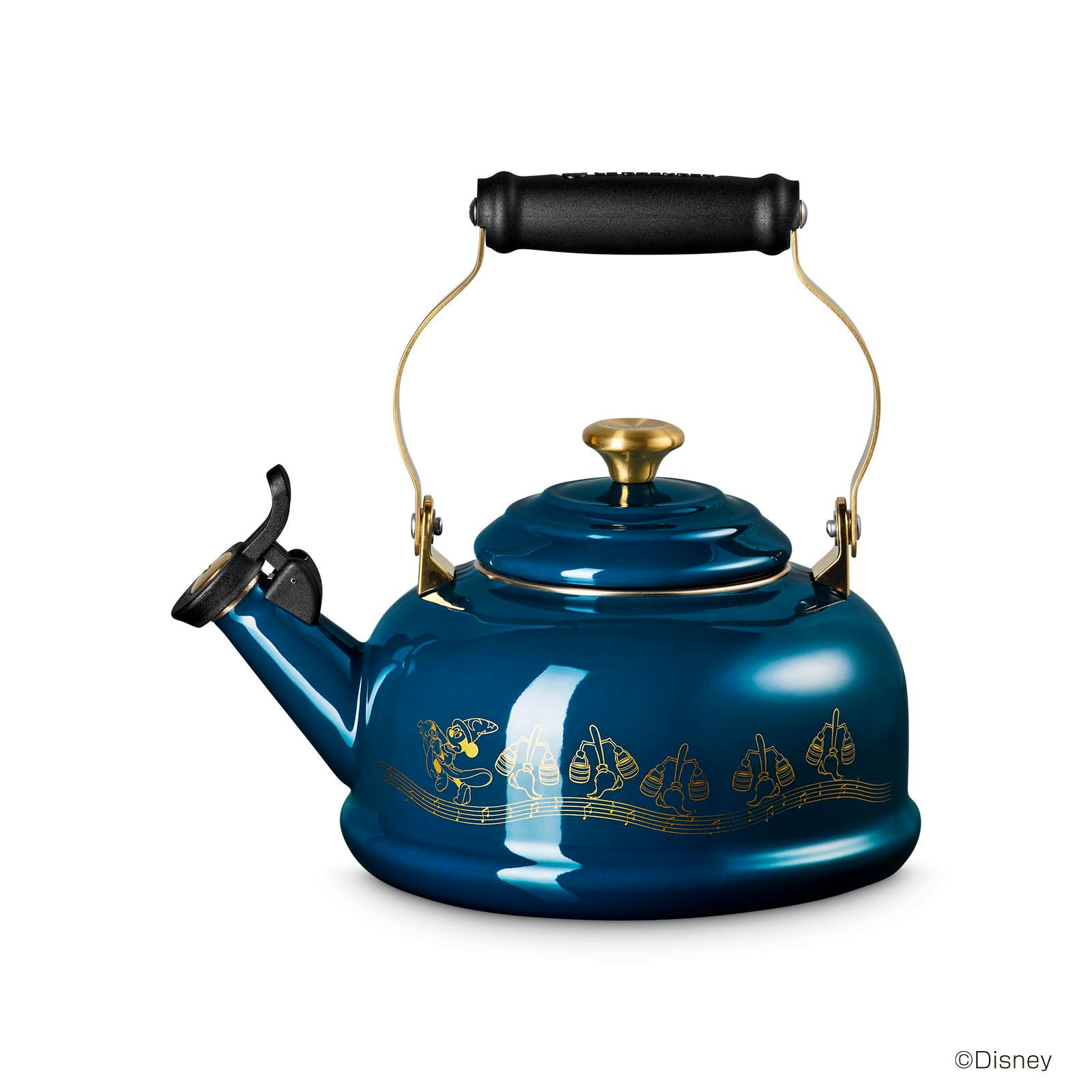 Blue stainless-steel kettle showing the lid and gold knob, black handle, spout with whistle, and gold decorative illustrations on the body.