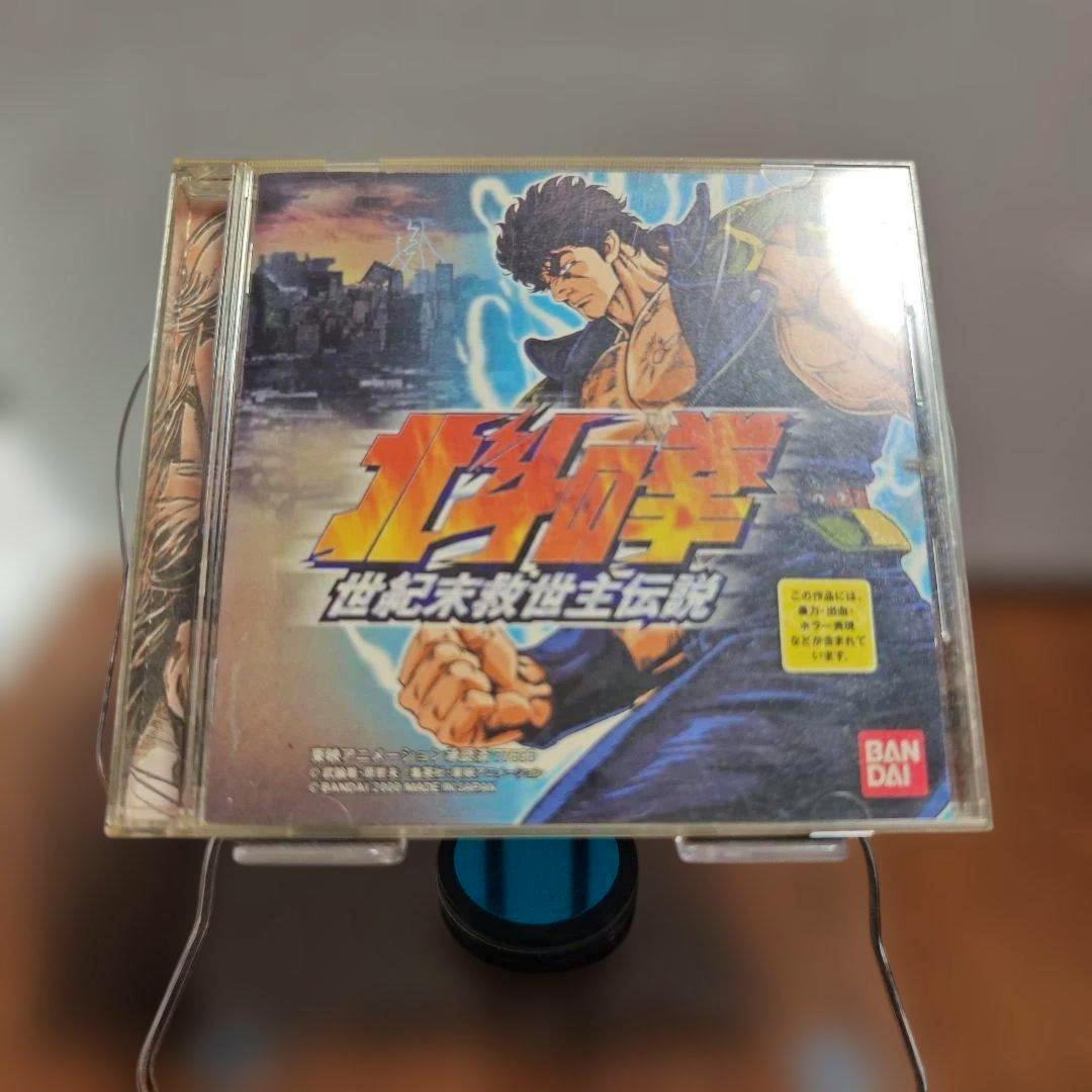 Front cover of the PS1 game 北斗の拳 世紀末救世主伝説 in a clear plastic case showing the illustrated artwork and Bandai logo.