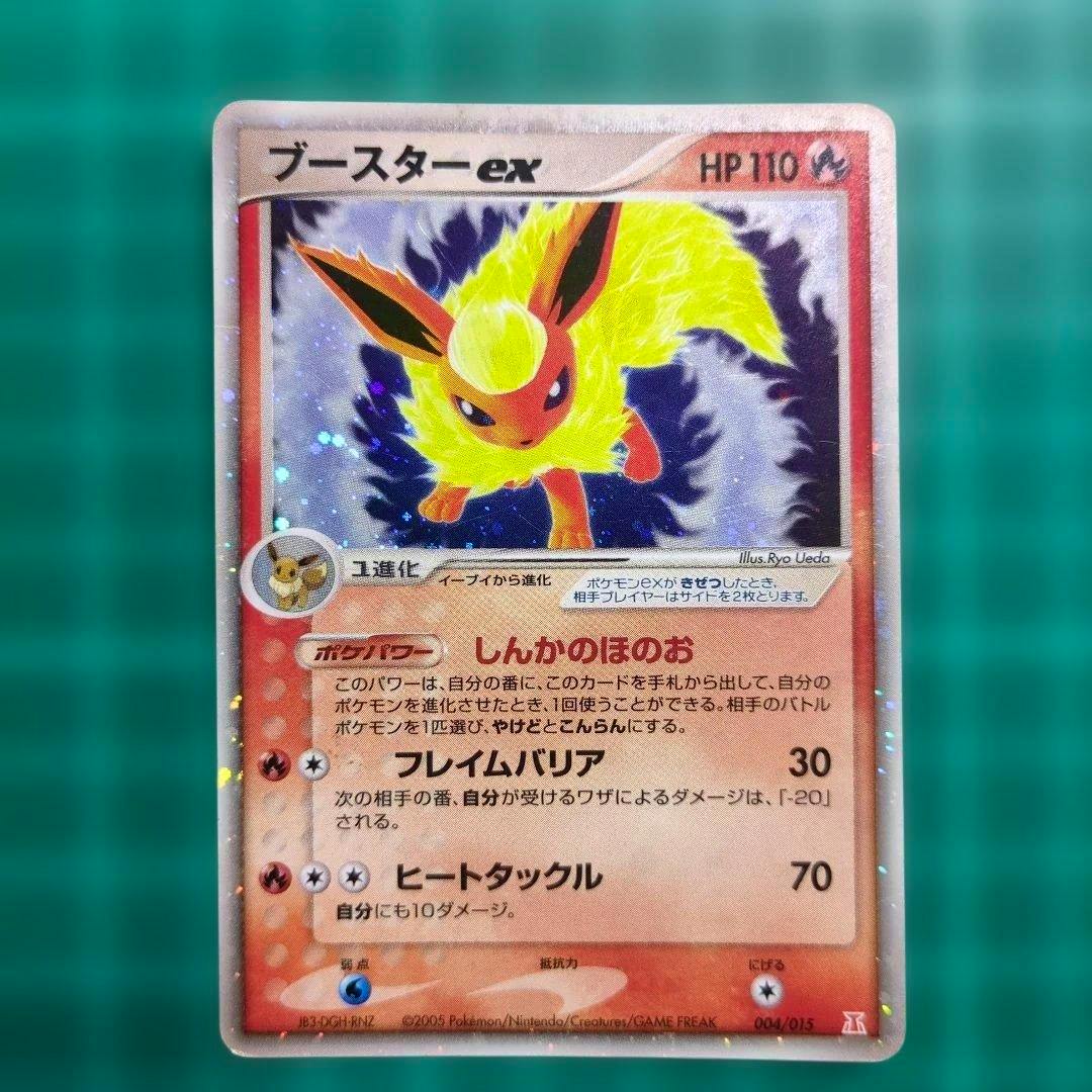 Photo of the ブースター-ex Japanese trading card showing the full holographic card front with Flareon artwork and Japanese text.